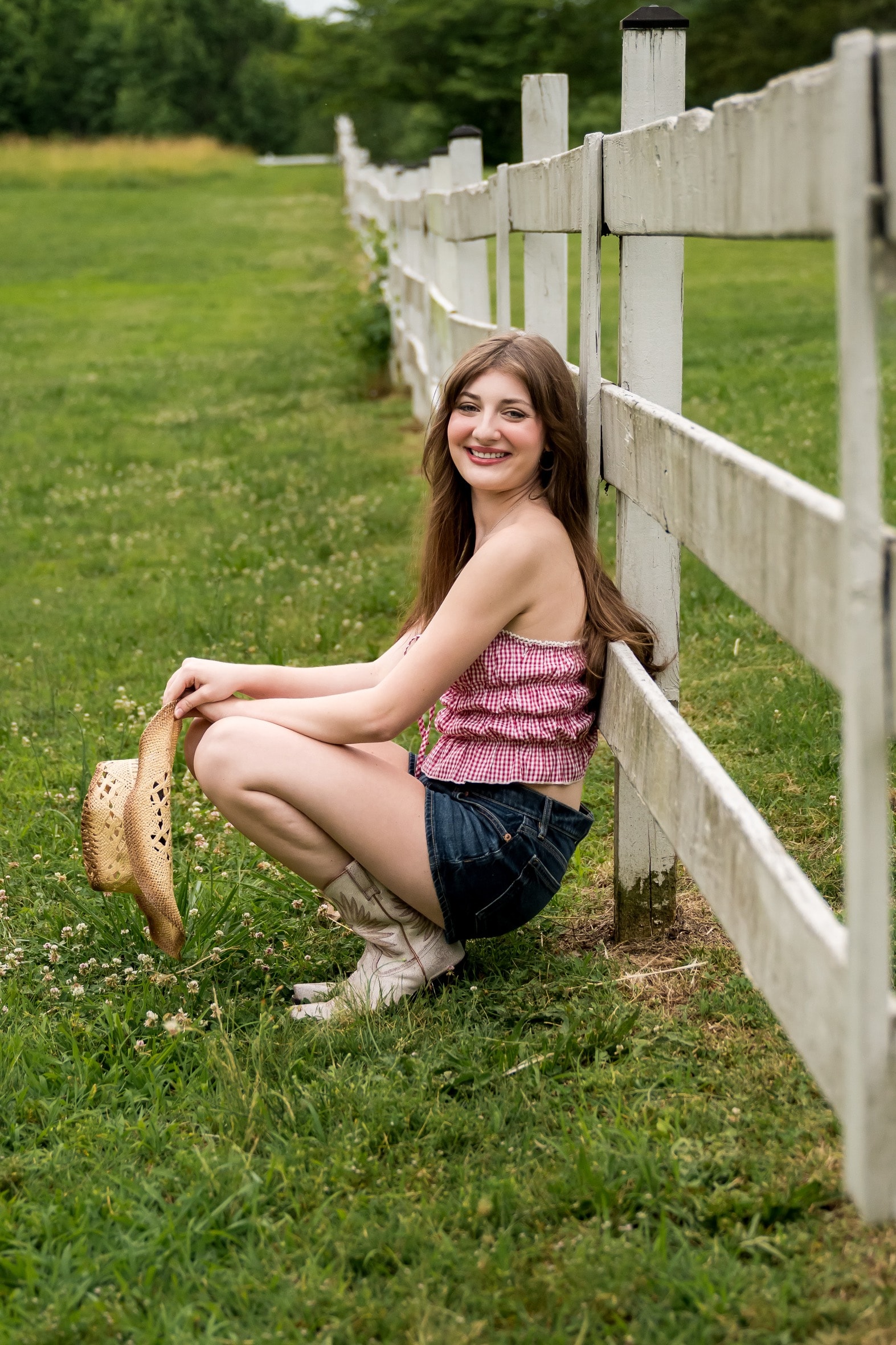 Savannah Lynn — seated by white fence in field